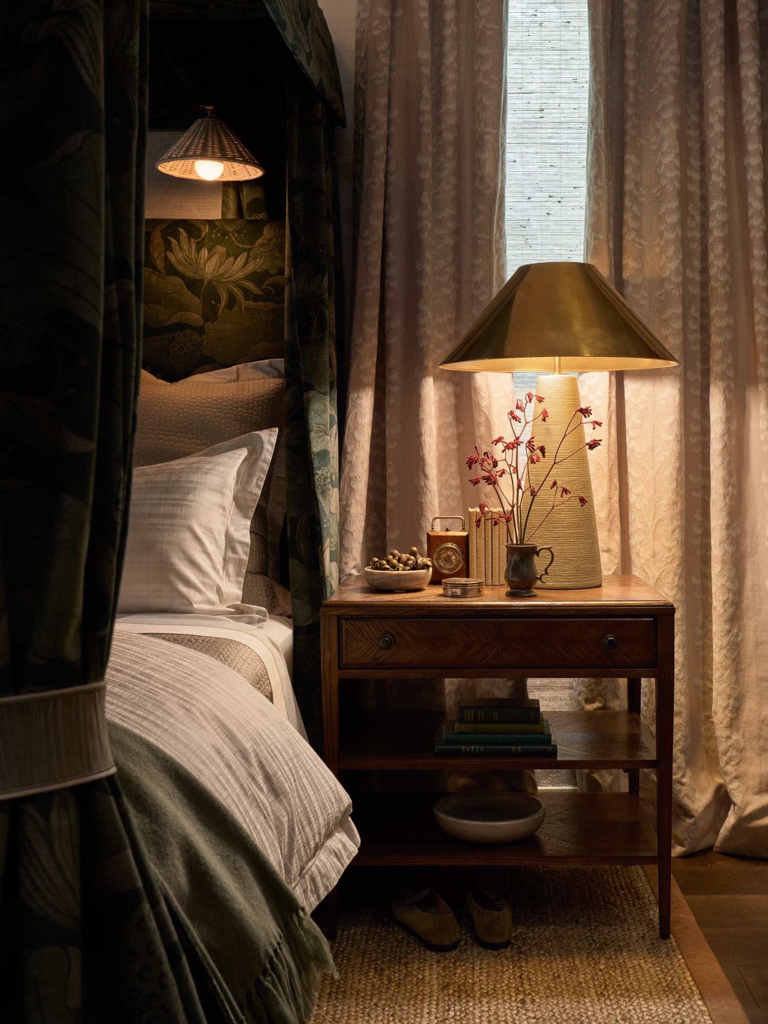 A brown wood nightstand next to a canopy bed in a cozy bedroom