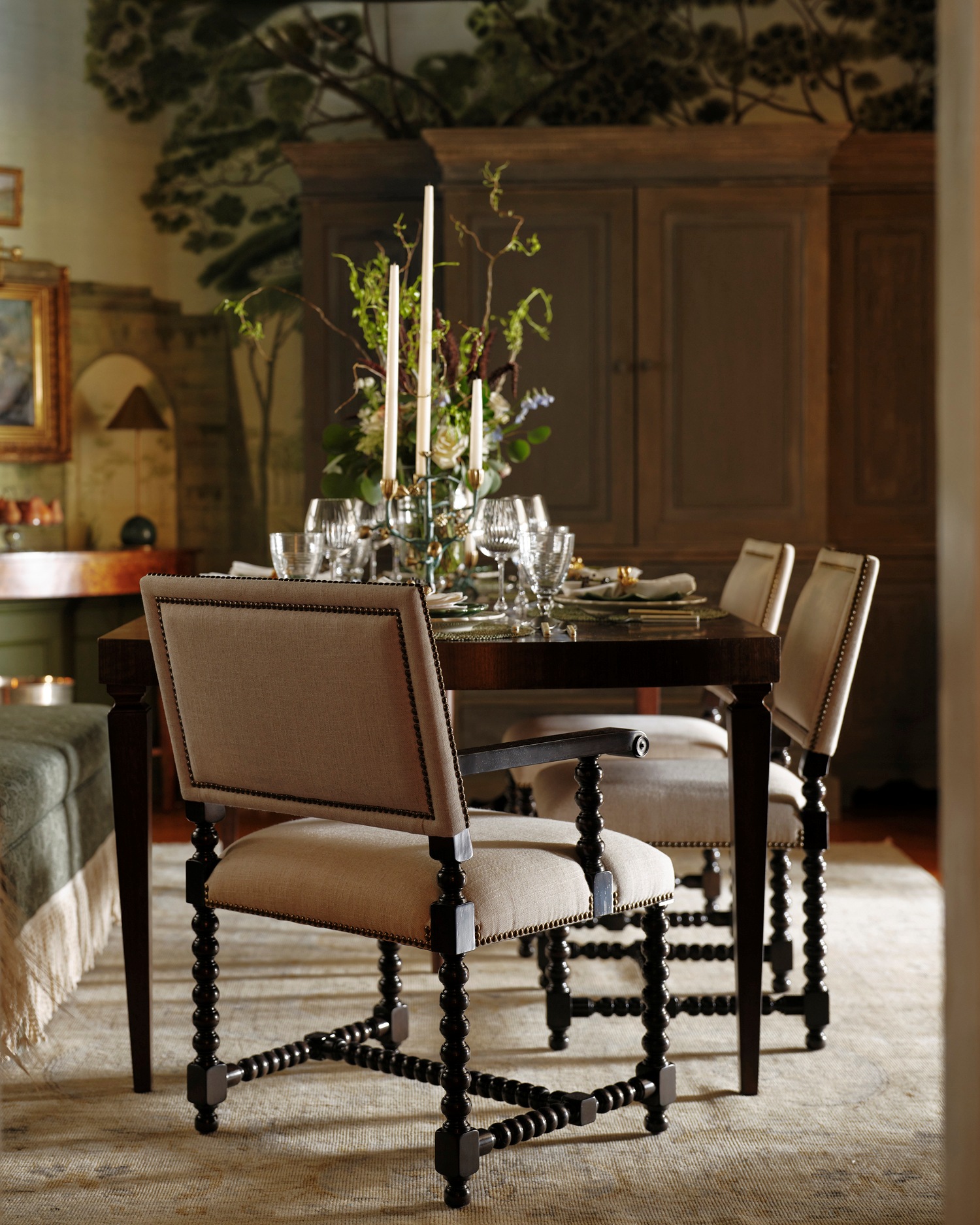 An apartment dining room with an extendable wood dining table and barley twist chairs